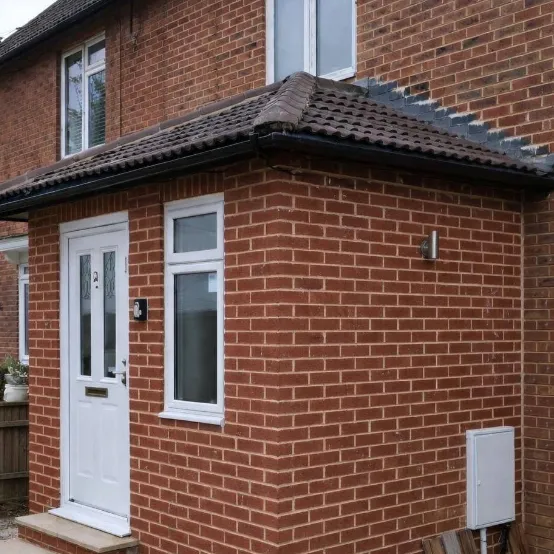 Brick-built porch with a tiled hipped roof and a white front door