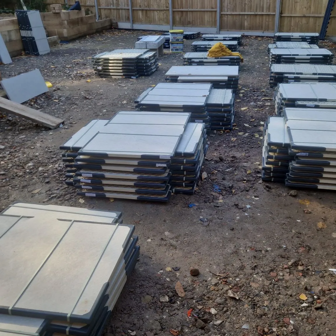 Pallets of grey paving slabs stacked on site ready to lay